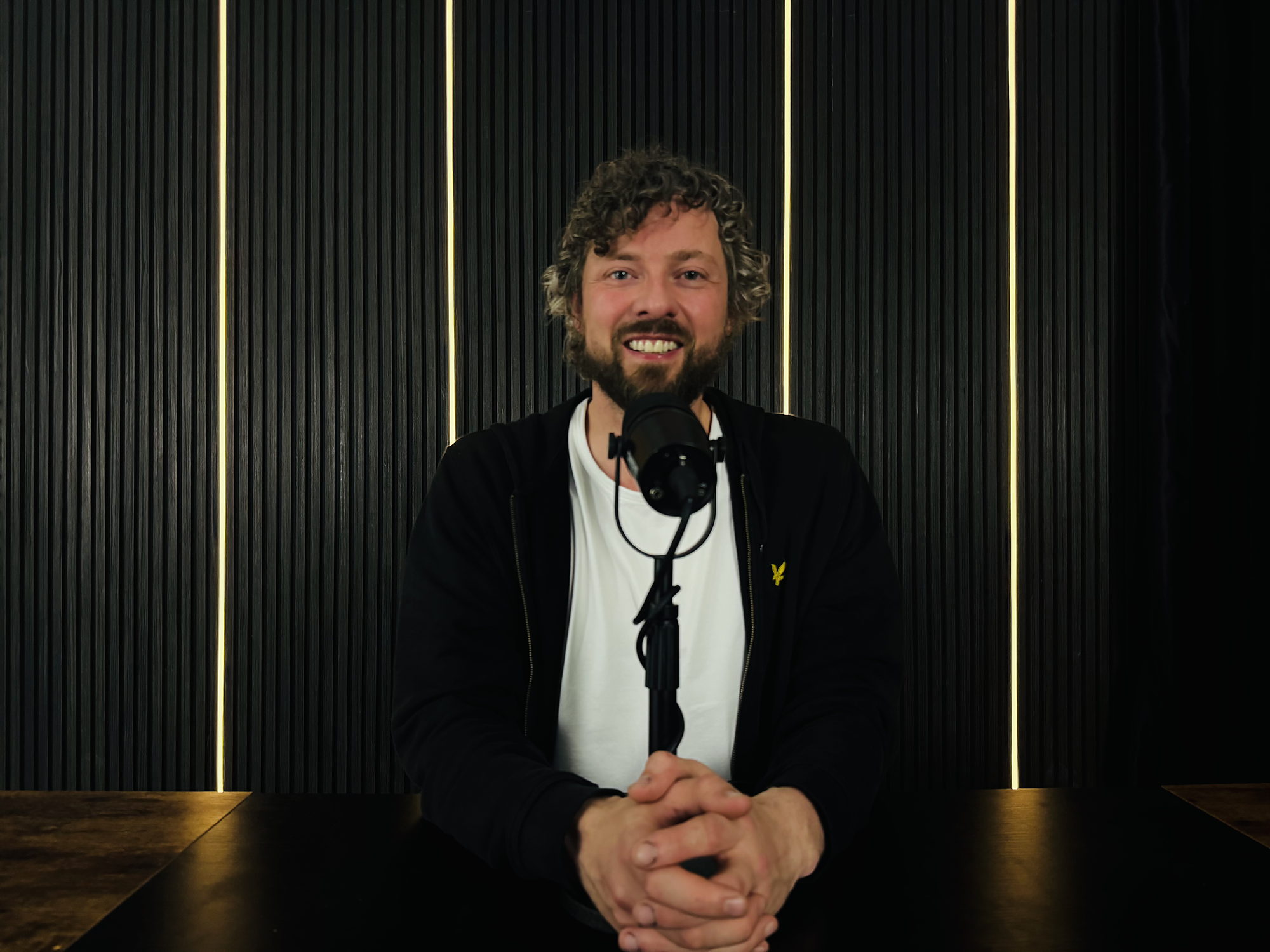 Presenter recording against the wood panel and LED wall